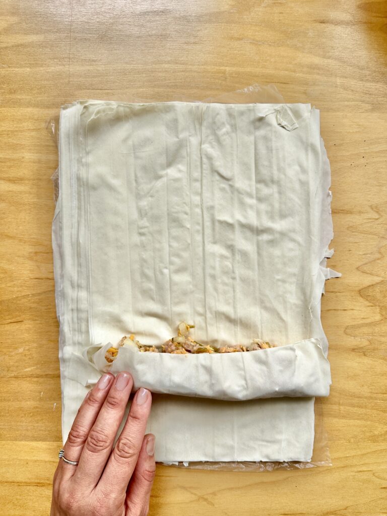 Ground Chicken Puff Pastries being rolled on a wooded table