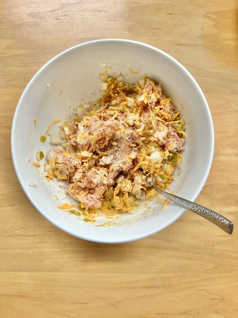 Chicken Pastries mixture in a bowl with a fork sticking out on a wooded table